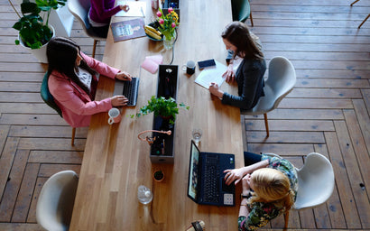 Workers share a desk in a co-working space